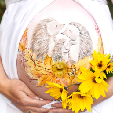 Bemalung auf Schwangerschaftsbauch mit einer Igelfamilie